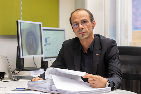 TU Graz researcher leafs through a file folder