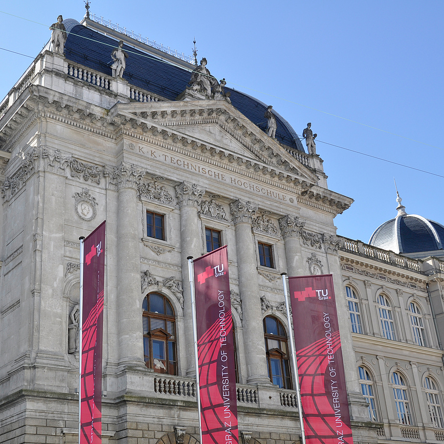 Historical building front with three red flags.