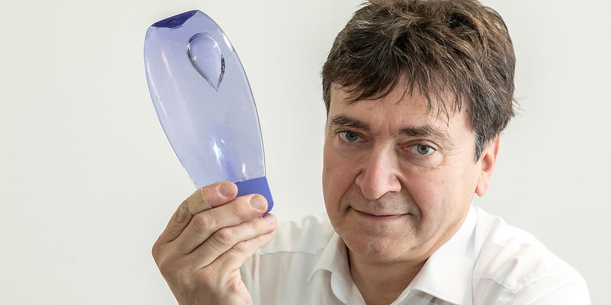 Man holds bottle in his hands in which gas bubbles rise