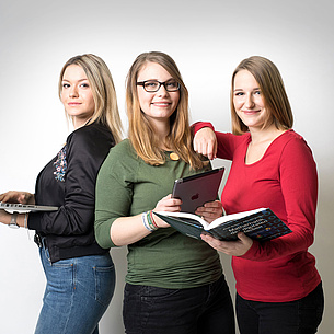 [Translate to Englisch:] 3 Studentinnen mit Notebook, Tablet und Lehrbuch in den Händen. Bildquelle: Kanizaj – TU Graz