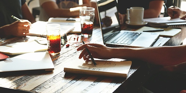 Menschen arbeiten gemeinsam an einem großen Tisch