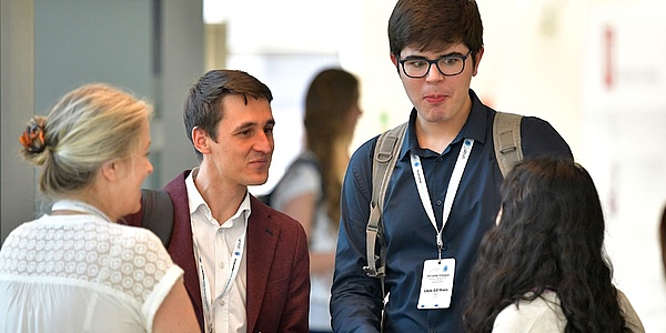 Four people are standing in a circle and talking animatedly.