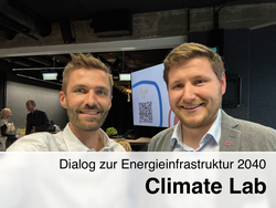 Robert Gaugl und Alexander Konrad vor einem Bildschirm mit dem Climate Lab Logo.