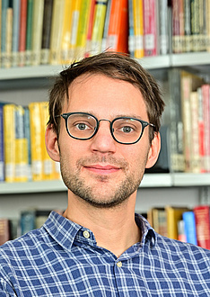 Researcher with checked shirt and glasses