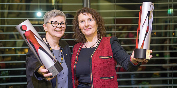 Two women with awards in their hands