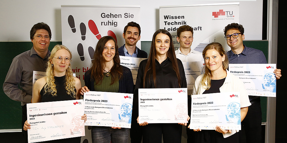 Four women and four men look into the camera and hold a certificate, the award for dissertations and master theses at TU Graz with special social relevance, in their hands, beaming with joy.