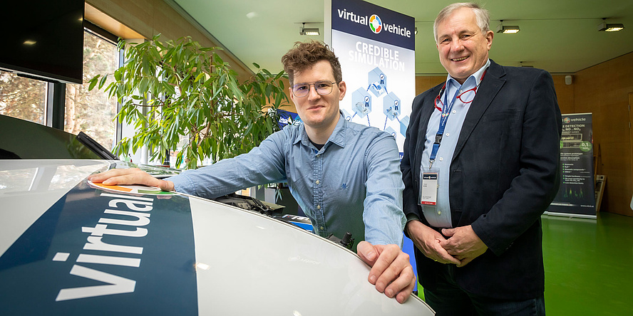 Two gentlemen standing behind the bonnet of a research vehicle