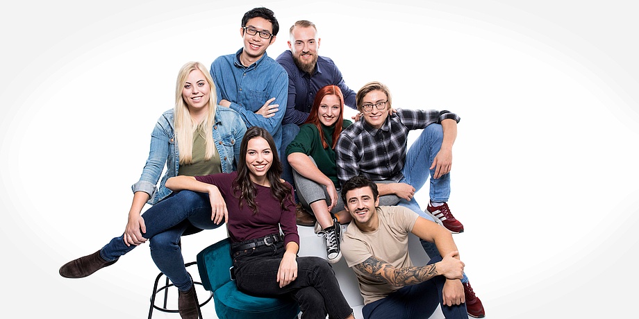 Dynamic group portrait with three young women and four young men