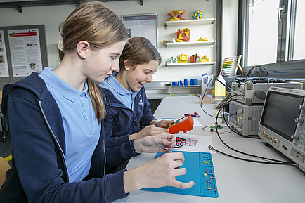 Two girls with electronic devices.