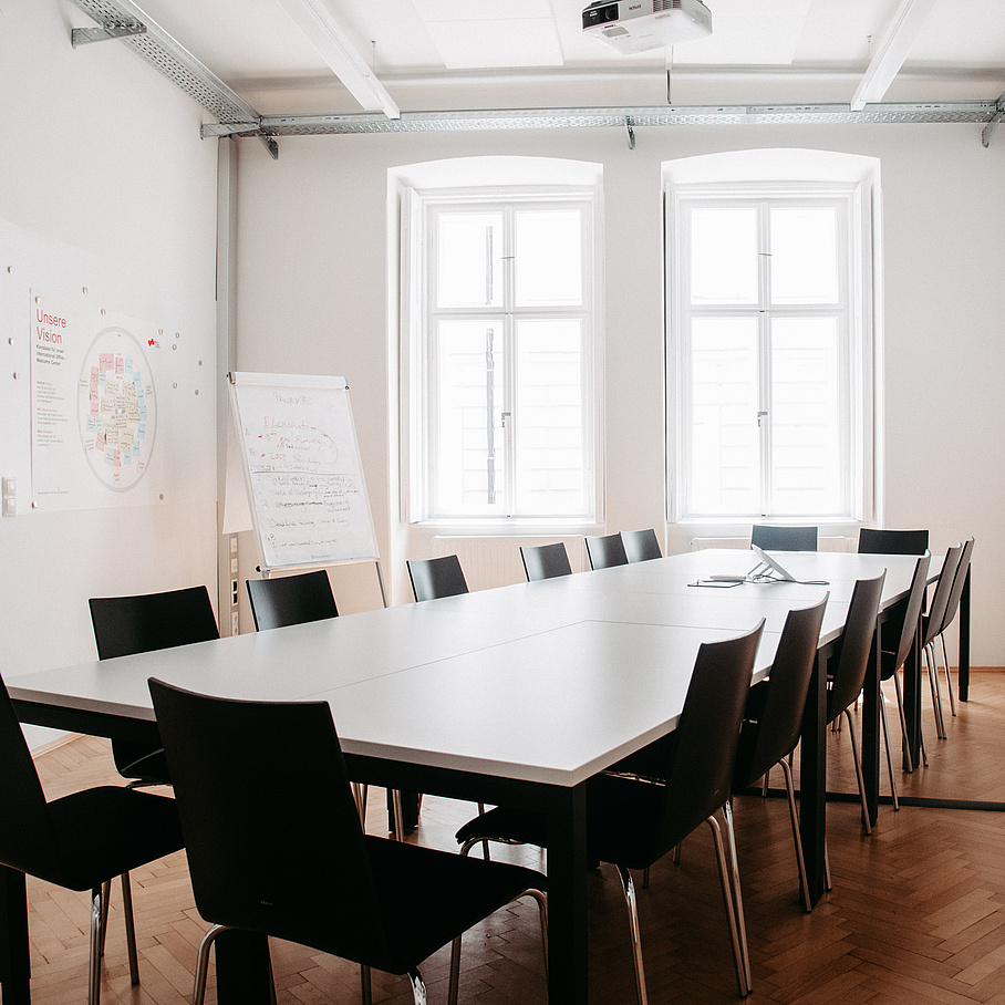 Besprechungsraum mit Tisch und Flipchart