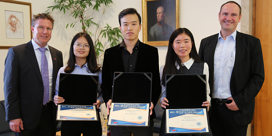 [Translate to Englisch:] three Cinese students - two female and one male show their scholarship documents into the camera, flanked by two gentlemen.