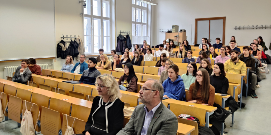 Personen sitzen in Hörsaal.