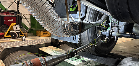 Photo of the underside of a car currently on a test bench. Hoses and pipes lead from the brake of a tyre to the side of the image.