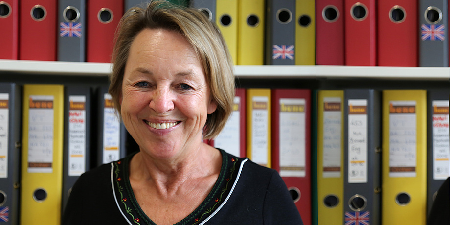 Anna Maria Moisi in front of a large number of files in her office at the Registration Office of TU Graz.