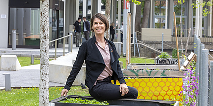 Daniela Fuchs-Hanusch sits on a raised bed and looks into the camera.