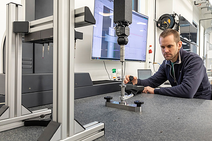 [Translate to Englisch:] TU Graz researcher operates a 3D coordinate measuring machine