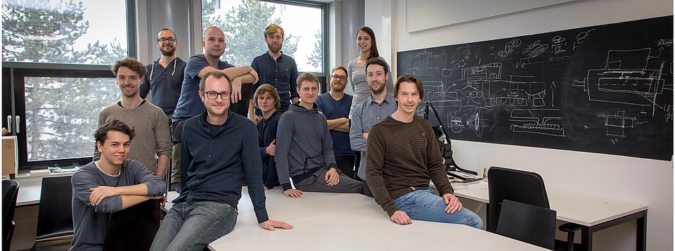 Group picture of the institute's team standing around a table.