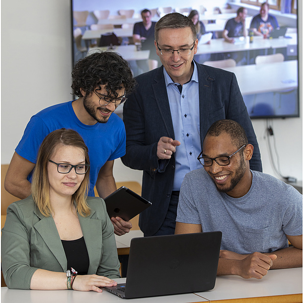 Supervisor and students working together on a project 