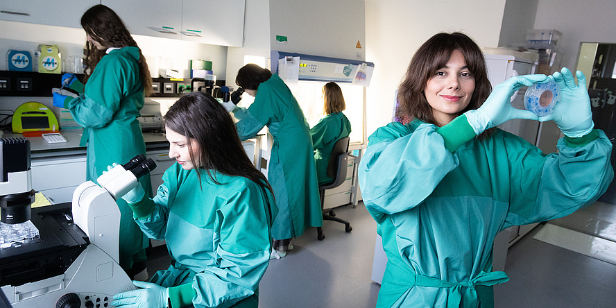 Fünf Forscherinnen in Labormänteln bei der Arbeit im Labor.