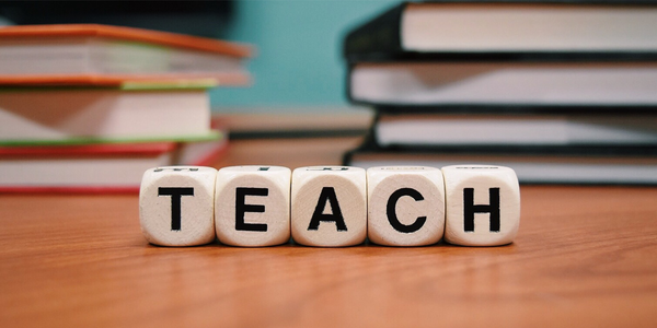 5 Würfel, die das Wort "Teach" zeigen