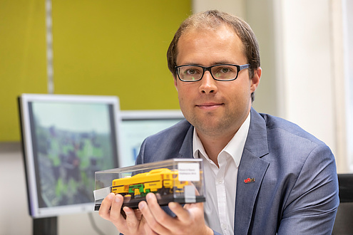 TU Graz researchers with model of a tamping machine