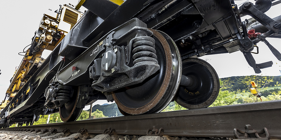 Close-up of a train axle travelling along a track.