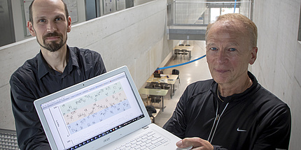 Two researchers with laptop in hand