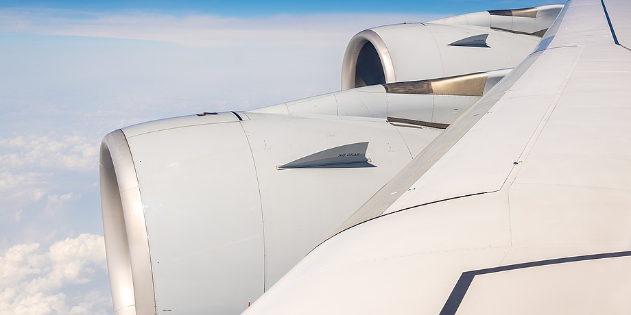 Flügel eines Airbus A380. Im Hintergrund sind Wolken zu sehen.