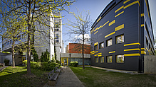 Zwei moderne Gebäude, eines weiß, das andere schwarz mit gelben Details.
