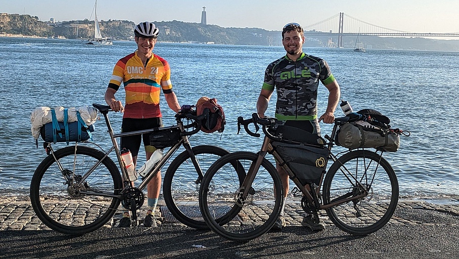 [Translate to Englisch:] two people with bikes standing in front of the sea