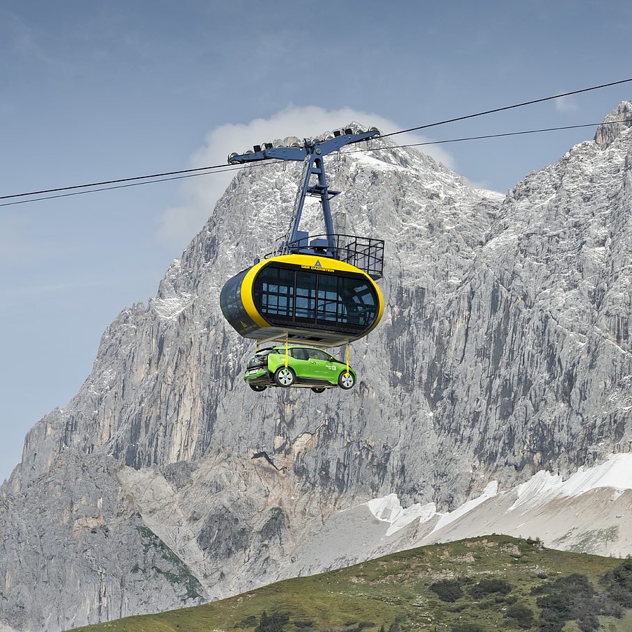 Gondel mit E-Auto, Berggipfel im Hintergrund