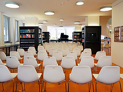 The reading room of the Main Library with chairs arranged in front of a stage with a piano.