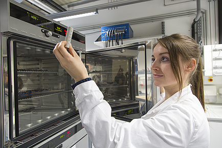 Woman looks at battery in her hand 