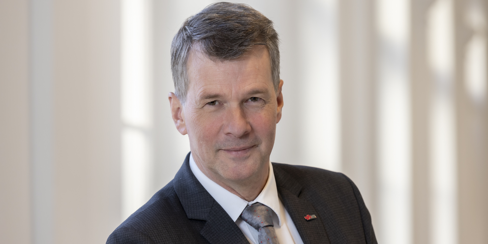 Freundlich lächelnder Mann mit Krawatte.