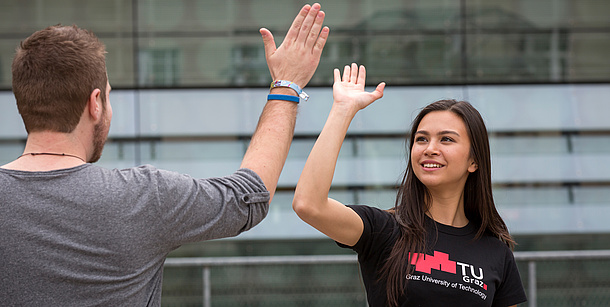 Ein junger Mann und eine junge Frau in TU Graz-T-Shirt geben sich High Five. Bildquelle: Lunghammer – TU Graz