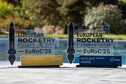 The trophies for overall victory and the H9 Flight Award. Image source: ASTG Two glass plaques with an image of a rocket on the left-hand side. The left-hand plaque is the prize for the EuRoC Award 2025, while the right-hand plaque is the prize for the H9 Flight Award.