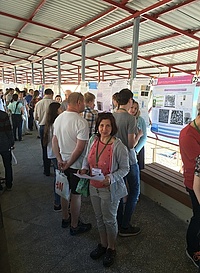 Larisa Karpenko-Jereb standing at the beach in front of the confernce posters.