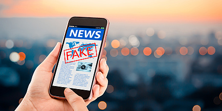 Handybildschirm mit der Aufschrift "Fake News".