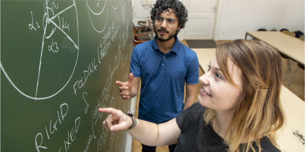 Two students at a blackboard.