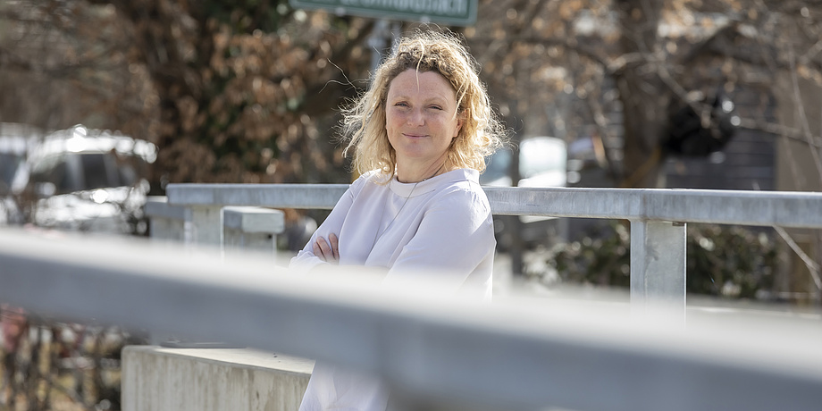 Eine Frau steht auf einer Brücke.