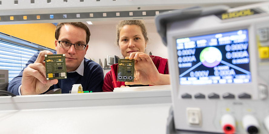 Forschende mit elektronischen Leiterplatten in Händen