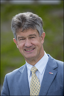 Rektor Harald Kainz im blauen Anzug mit gelber Krawatte