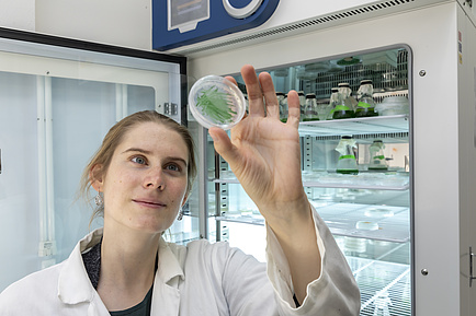 Woman holding small can with algae sample 