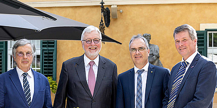 Four men smile into the camera