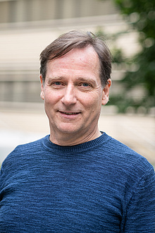 A man smiles into the camera.