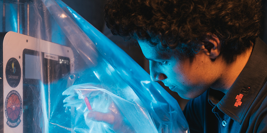 A young man touches a component about five centimeters in size through a plastic shell.