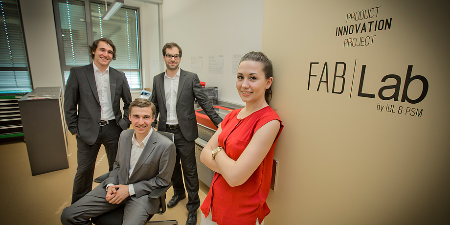 A Product Innovation Project team, three male and one female students in front of the FabLab of TU Graz.