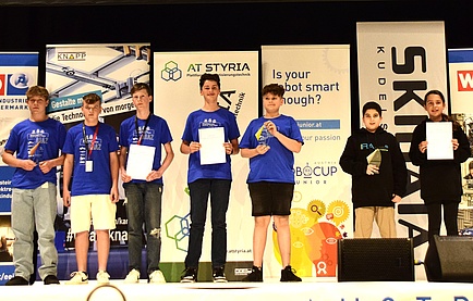 Seven people stand on a stage.