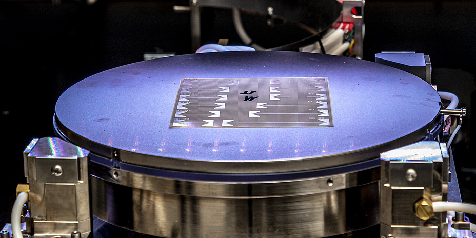 Ein dünnes, silbriges Objekt auf einer kreisrunden, beleuchteten Unterlage.