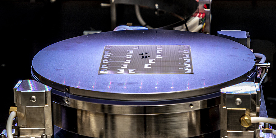 Ein dünnes, silbriges Objekt auf einer kreisrunden, beleuchteten Unterlage.